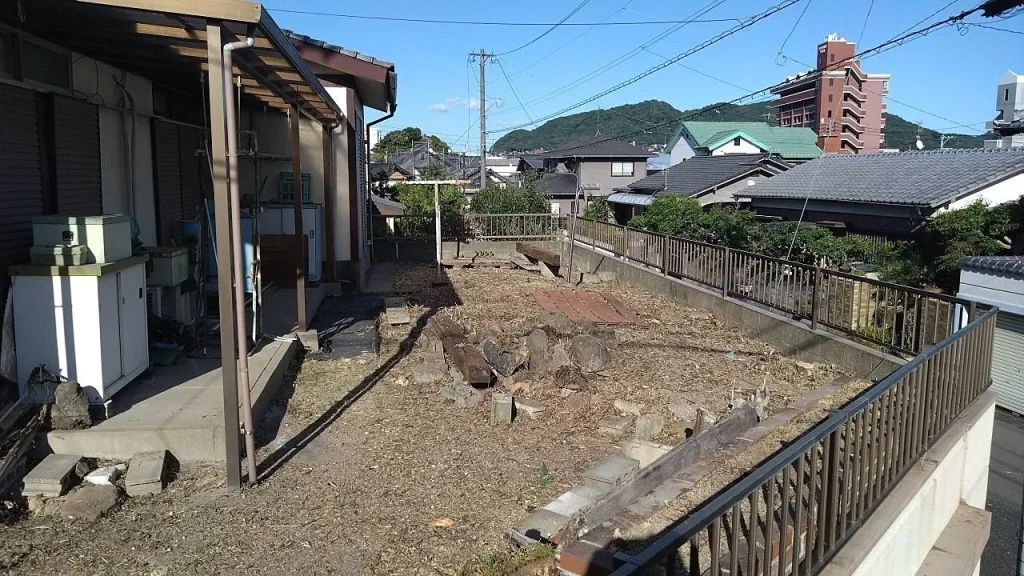 除草作業で通行しやすくなった建物裏の通路