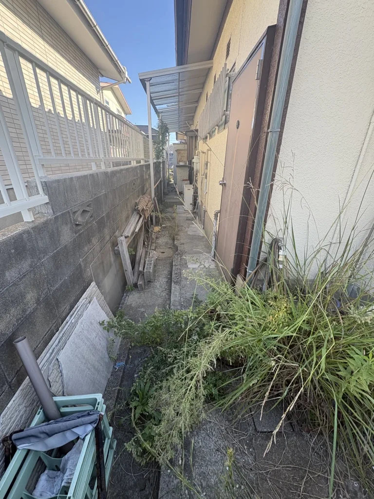 住宅側面の通路に雑草が生えている施工前の様子